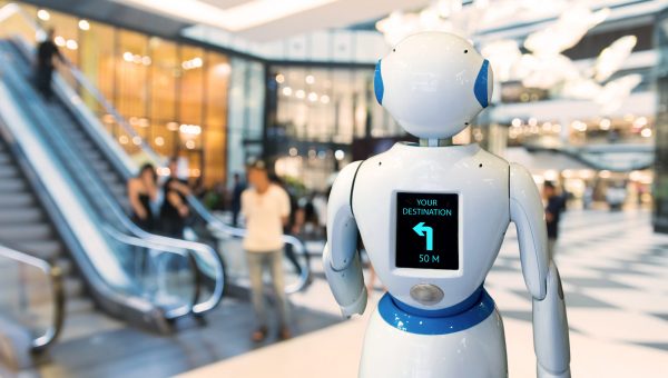 Roboter im Laden fährt eigenständig auf der Ladenfläche und zeigt auf einem Bildschirm den Weg an.